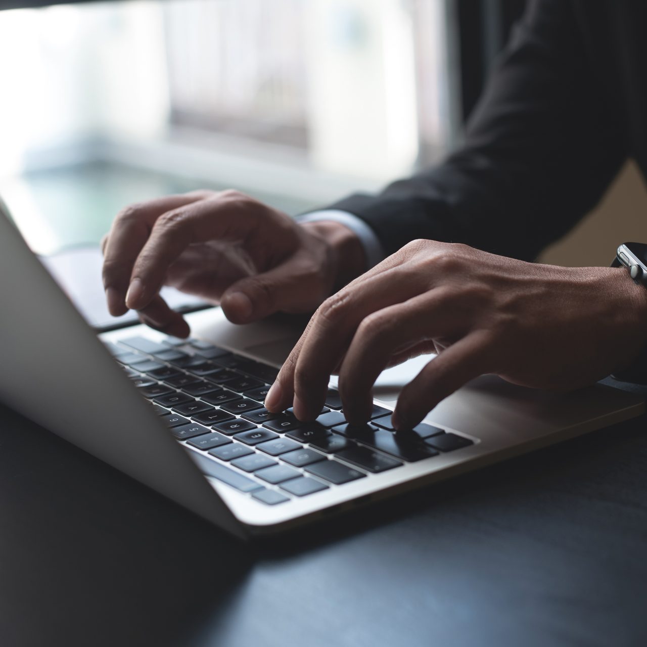 man typing on a laptop