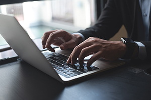 man typing on a laptop